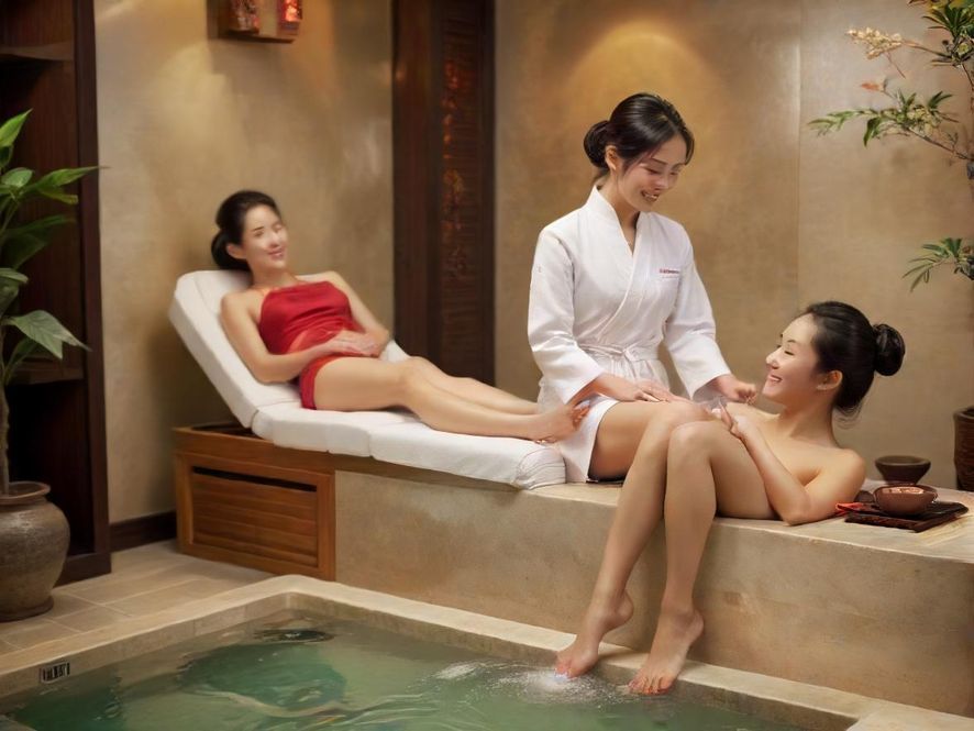 一位专业的足疗师正在为顾客提供服务,顾客脸上洋溢着放松的笑容,背景是现代中式风格的舒适足浴沙发。